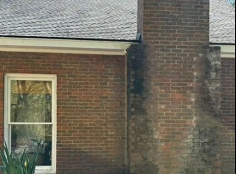 Black streaking down brick below the roof line