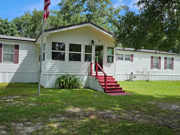 Manufactured home with clean white siding and red front steps
