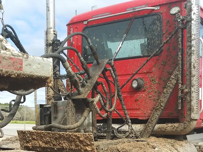 Heavy equipment and tank covered in road film before washing