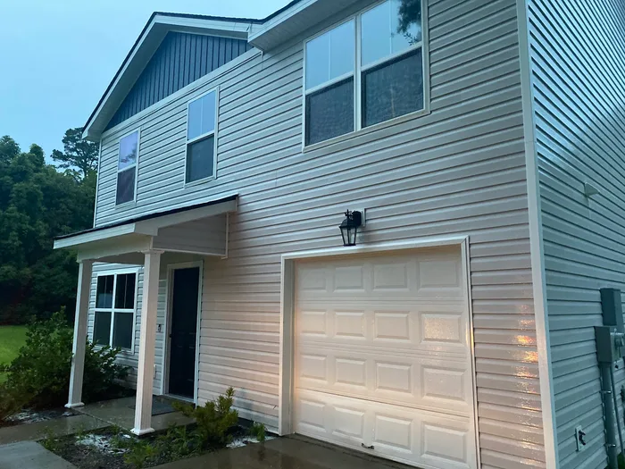 Two story home with clean siding and garage after washing